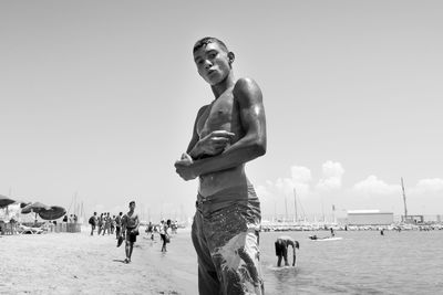 Man standing at beach against clear sky