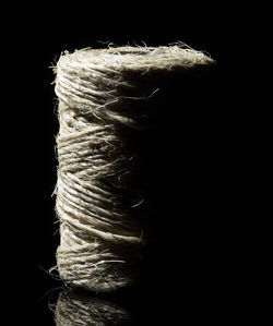 Close-up of rope tied up on black background