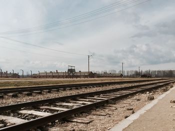 Railroad tracks on field against sky