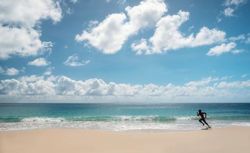 Man surfing in sea against sky