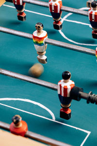 High angle of detail of retro table soccer with wooden miniature figurines of players on metal bars