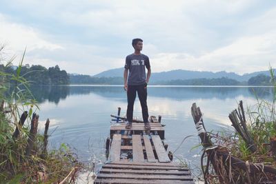 Man standing on pier at lake