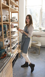 Female ceramist and her new collection of ceramic tableware in the studio of clay and sculpture.