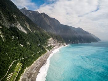 Scenic view of sea and mountains against sky