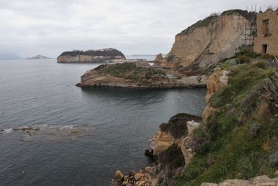 Rock formations by sea against sky