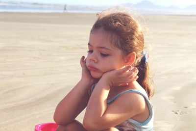 Close-up of girl playing in sand at beach