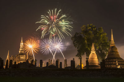 Firework display over city lit up at night