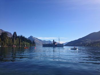 People on boat sailing in river against clear sky