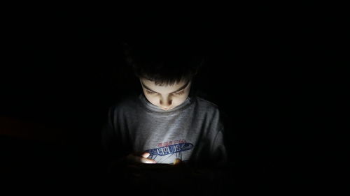 Portrait of boy wearing hat against black background