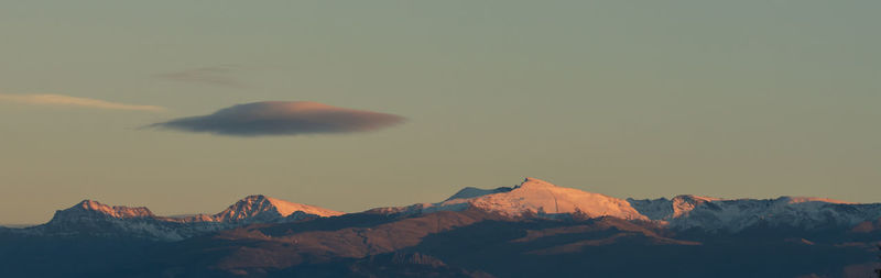 Scenic view of snowcapped mountains against sky during sunset