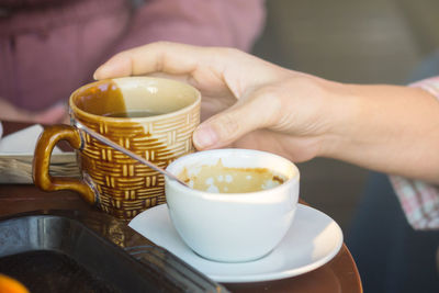 Cropped hand of person having coffee
