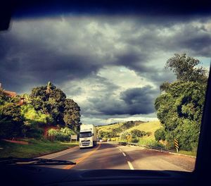 Road amidst trees against sky