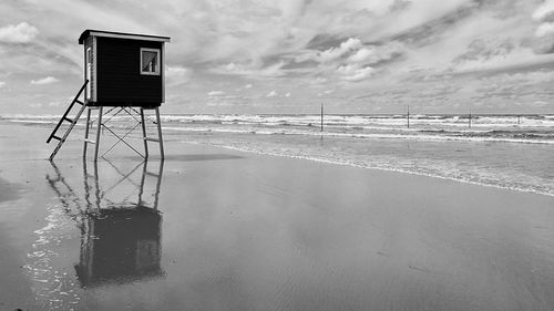 Lifeguard hut on beach against sky