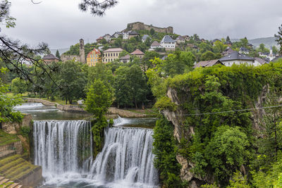 View of waterfall with building in background