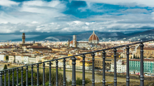 View of buildings in city against cloudy sky