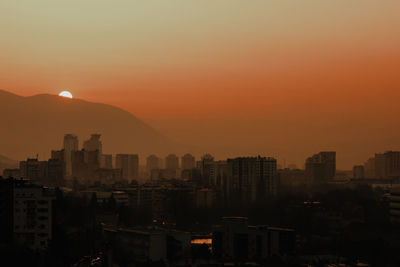 Silhouette buildings against sky during sunset