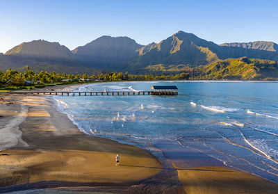 Aerial panoramic image at sunrise off the coast over hanalei bay and pier on kauai