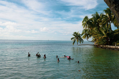 People enjoying in sea against sky