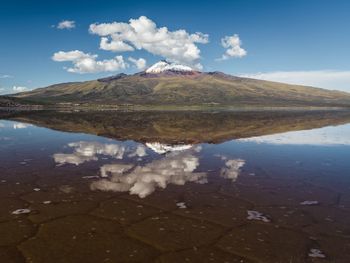 Scenic view of lake by mountains against sky