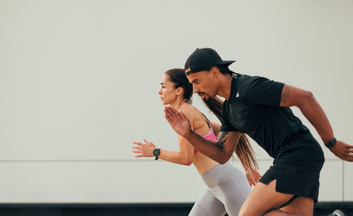 Side view of young woman exercising at home