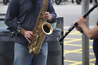 People playing musical instruments while standing on street