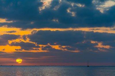 Scenic view of sea against dramatic sky during sunset