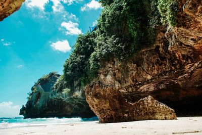 Rock formation on beach against sky