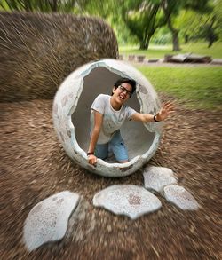 Teenage boy screaming while kneeling in concrete structure