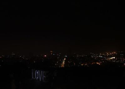 Illuminated cityscape against sky at night