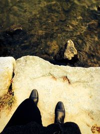 Low section of man standing on rock