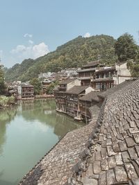 Scenic view of lake by buildings against sky