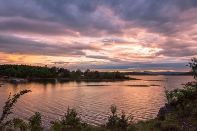 Scenic view of river against sky at sunset