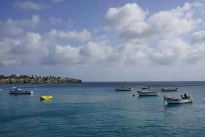 Sailboats in sea against sky