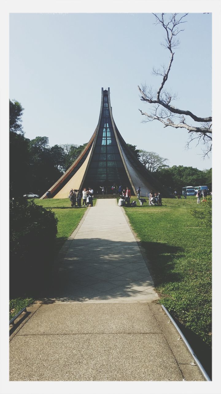 transfer print, auto post production filter, tree, grass, built structure, architecture, clear sky, building exterior, park - man made space, sky, footpath, lawn, sunlight, travel destinations, outdoors, day, incidental people, park, famous place, city