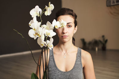 Young woman 30 years old with flowers and home flowerpots