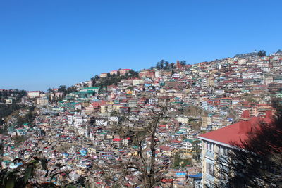 Buildings in city against clear blue sky