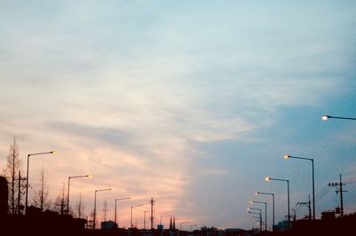 Low angle view of street lights against sky during sunset