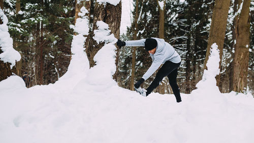 Young man standing on snow covered field