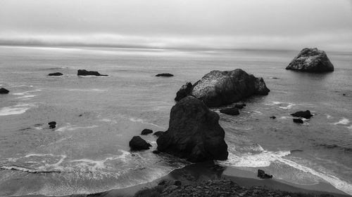 Rocks on sea shore against sky