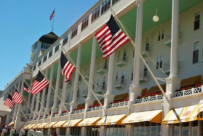Low angle view of flags on building against sky
