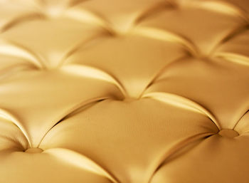 Close-up of gold chesterfield sofa