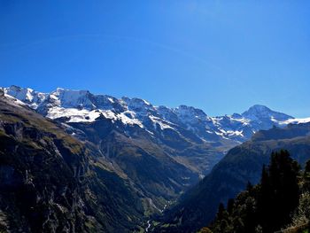 Scenic view of snowcapped mountains against clear blue sky