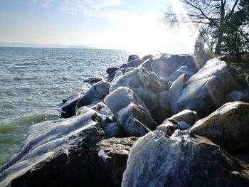 Rocks on beach against sky