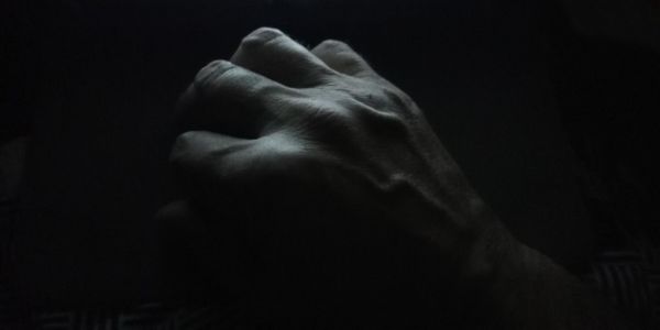 Close-up of human hand against black background