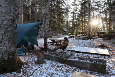 Woman relaxing at campsite during winter