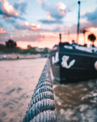 Close-up of sailboat against sea during sunset