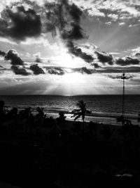 Silhouette people on beach against sky