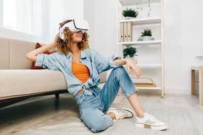 Young woman sitting on sofa at home