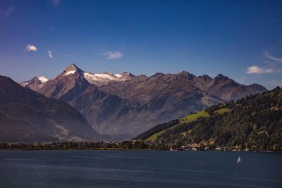 Scenic view of lake and mountains against blue sky