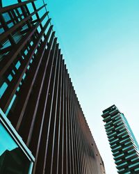 Low angle view of skyscrapers against blue sky